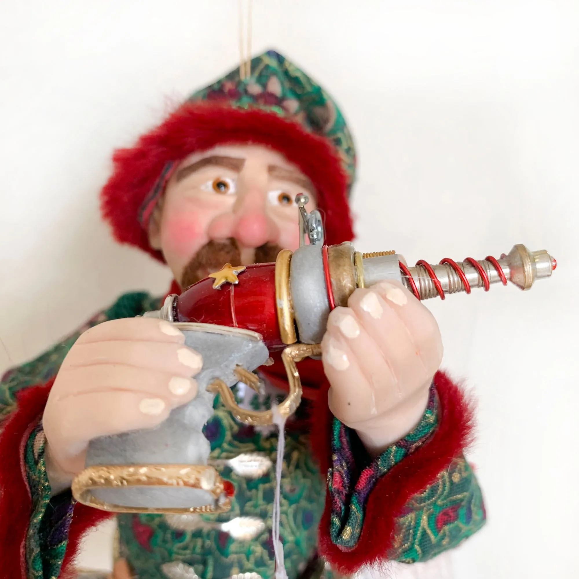 Christmas ornament - Spaceman Elf #443 inspecting a Ray Gun