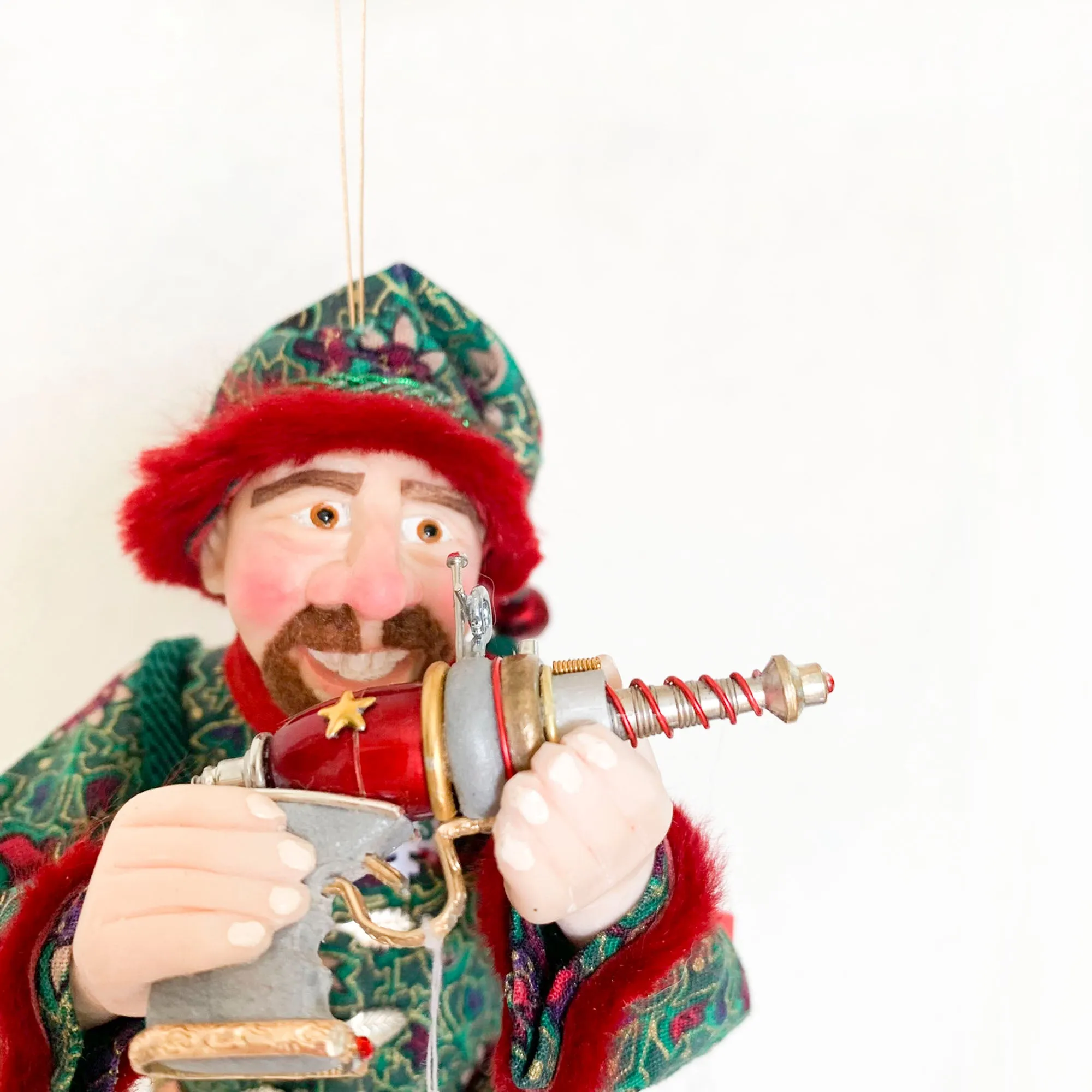 Christmas ornament - Spaceman Elf #443 inspecting a Ray Gun